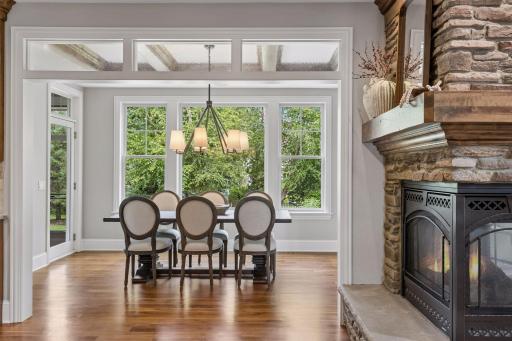 The dining room featues a wood coffered ceiling, convenient acces to the screened porch, and a wall of windows filing the room with natural light.