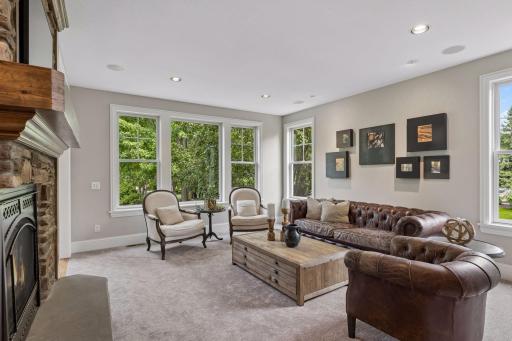 The livingroom includes large, bright windows, the cozy 3-side stone fireplace, and new carpet.