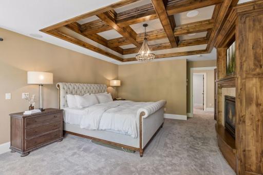 Another view of the primary bedroom and the stunning knotty alder wood coffered ceiling.