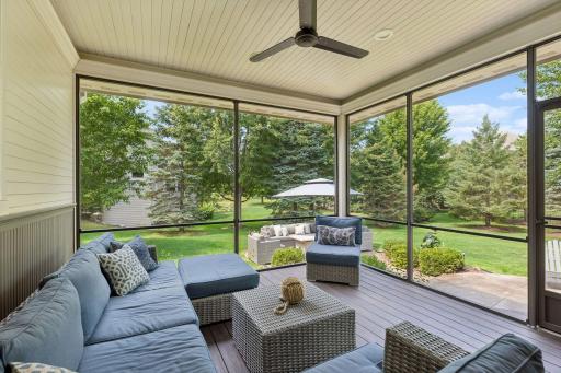 Another view of the screened porch overlooking the stamped concrete patio and wooded backyard.