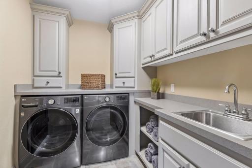 The laundry room provides convenient access to all rooms on the upper level. It features front-loading LG washer and gas dryer, a folding counter, storage and a utility sink.