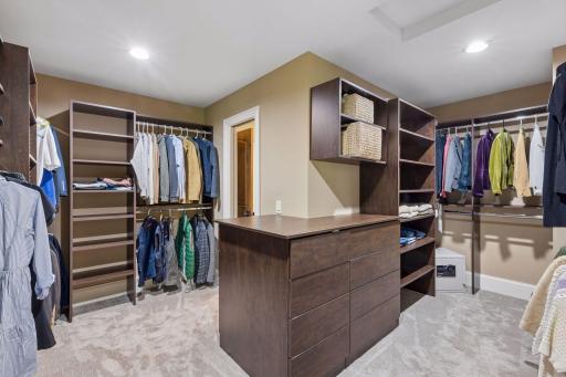 Dreams come true with this massive primary walk-in closet with organizational system. It provides access to the primary bathroom and to the upper-level laundry room through a pocket door.