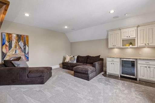 The upper level includes an additional family room. It's perfect for entertaining or hanging out with friends and includes built-in cabinets and a convenient beverage refrigerator.