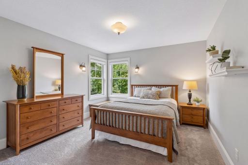 This home features 4 bedrooms on the upper level. This one features corner windows with a built-in storage bench and a spacious closet with organizational system and French doors.