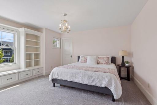 Another spacious bedroom on the upper level featuring built-in desk, bench with bookshelves & cubbies, a walk-in closet with a window and access to the full Jack & Jill bathroom.