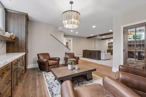 The lower level was completely finished in 2024. It features 9 ft ceilings, a spacious family room with built-in shelves & storage, wood ceiling beams, stone gas fireplace, LVT plank flooring & a large bar & entertainment center.