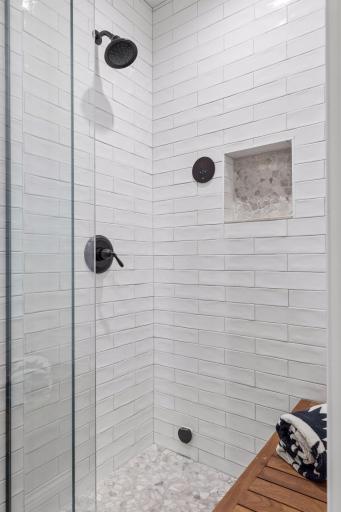 View of the beautiful shower with a built-in bench and tile surround.