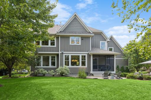 Another view of the lovely backyard that includes beautiful landscaping and mature trees.