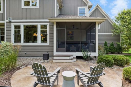 The view highlights the entertaining areas of the screen porch and part of the large stamped concrete patio.