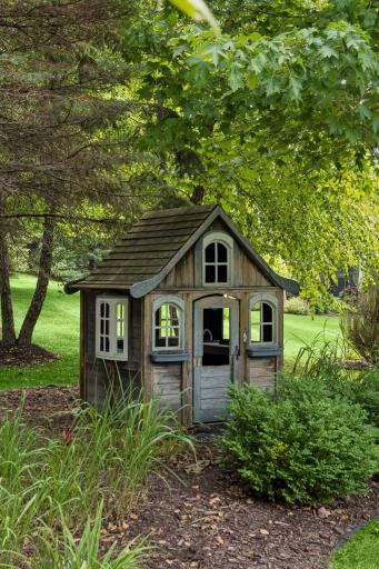 Don't miss the adorable playhouse blending into the landscaping and trees.