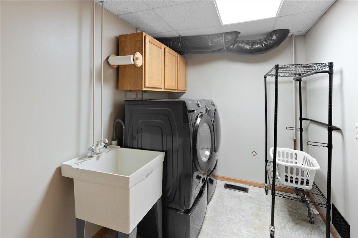 A Laundry Room That Works Hard Upper cabinets, open shelving, and a utility sink provide practical organization for laundry, lake towels, and everyday cleanup.