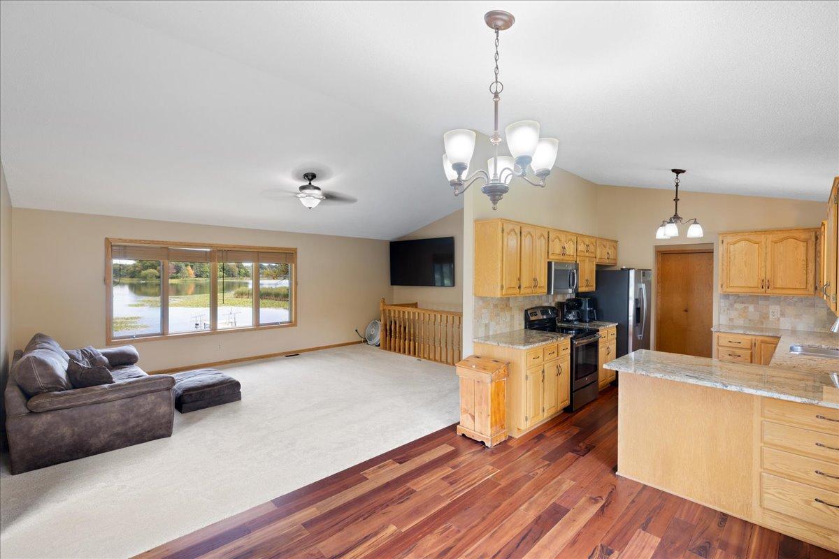 The Lake Is Part of the Room Vaulted ceilings and a picture window fill the open living area with light and showcase beautiful North Center Lake views.