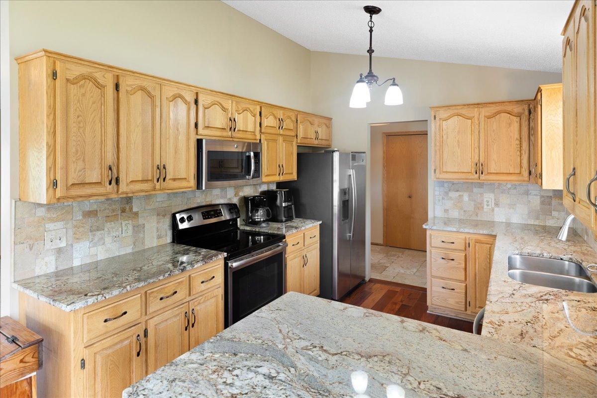 Warm Finishes With Lasting Appeal Natural wood cabinetry, Typhoon Bordeaux granite, and rich flooring bring warmth and character into the heart of the home.
