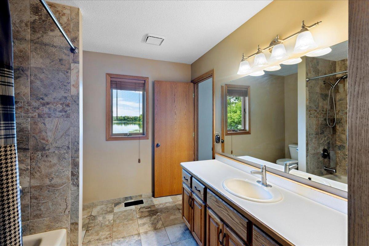 A Bathroom With a Lake View Natural finishes, generous vanity space, and a window overlooking North Center Lake make the morning routine feel a little more peaceful.