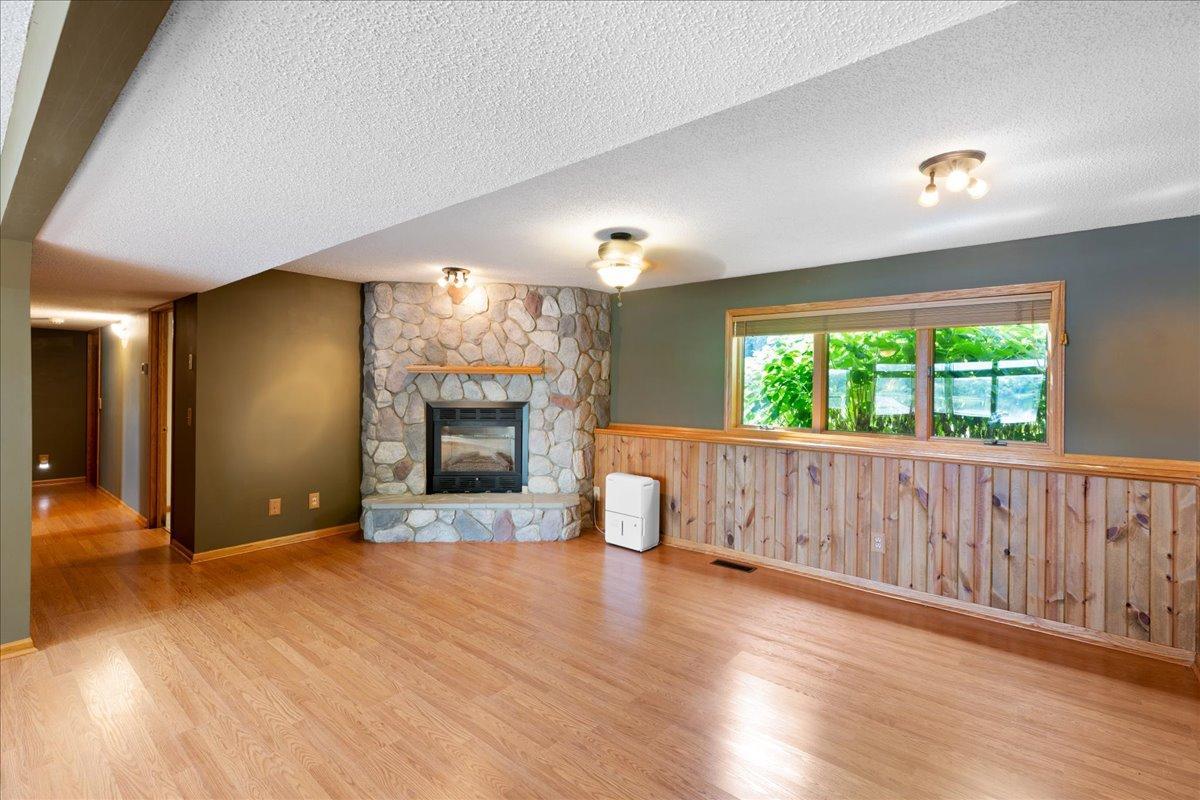 Lower Level family room with walkout to lake offers stone surround FP powered by natural gas.