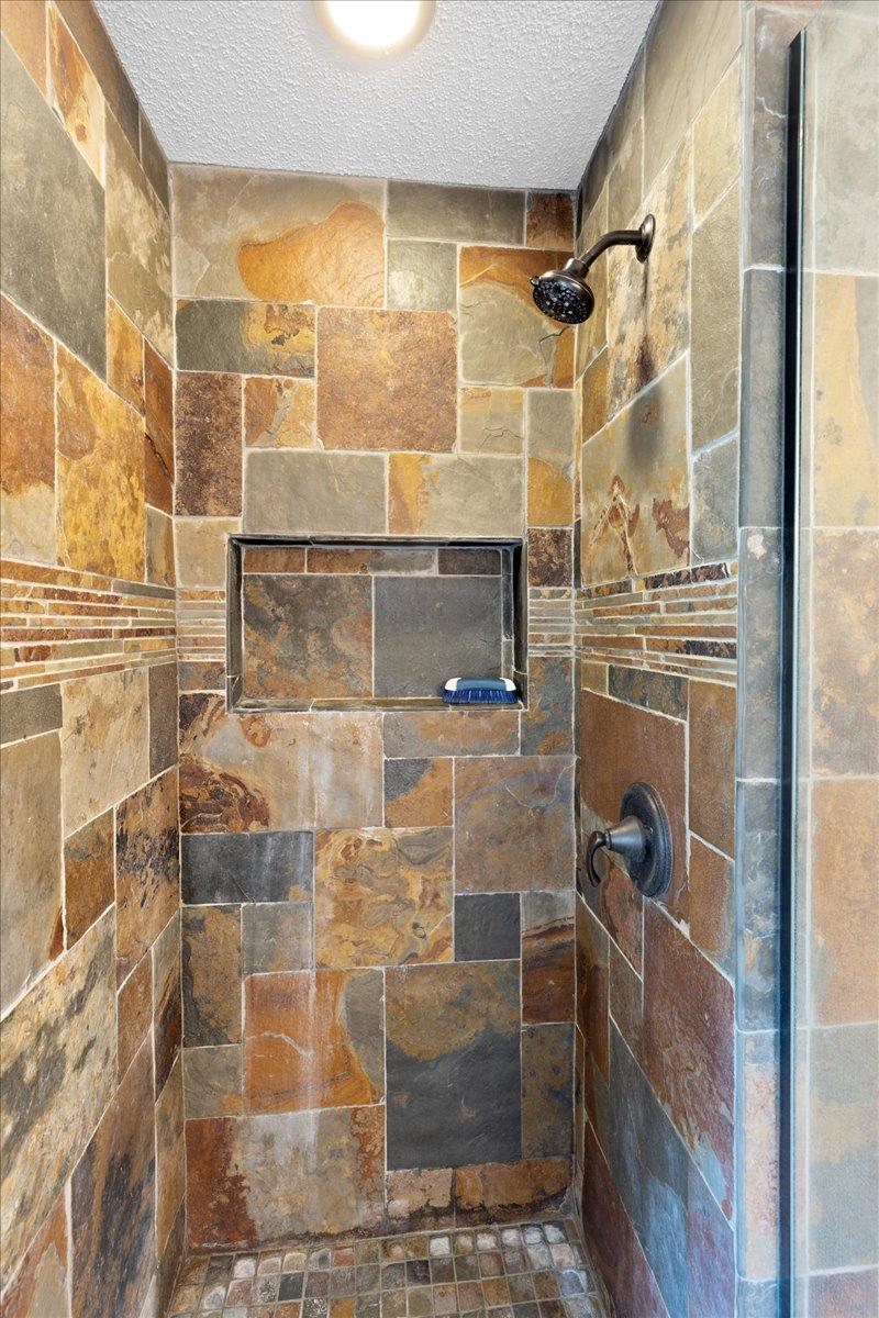 Beautifully Tiled Walk-In Shower Natural stone tile, decorative accents, and a built-in niche add distinctive character to this updated shower.