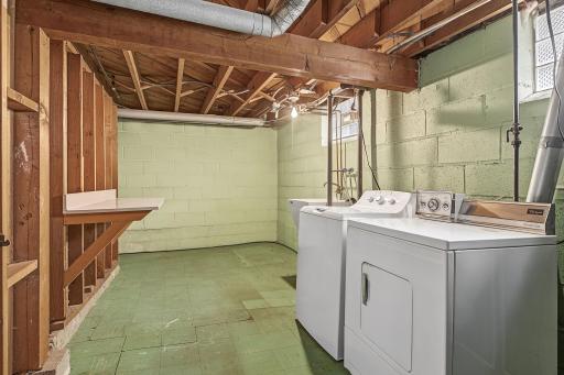 Dedicated laundry room with with a convenient laundry sink and generous folding counter.