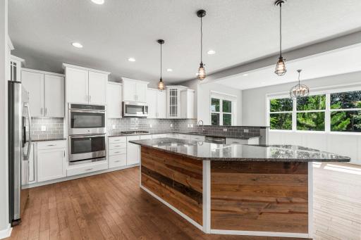 Designed with both function and style in mind, the kitchen offers stainless steel appliances including a cooktop and double ovens.