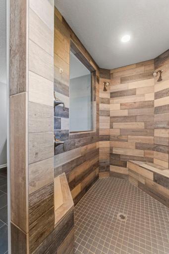 Tiled walk-in shower with dual shower heads and seating!