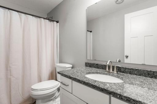 Lower level full bathroom nearby. Storage is plentiful throughout, including the utility room complete with a workbench and extra space for organization.