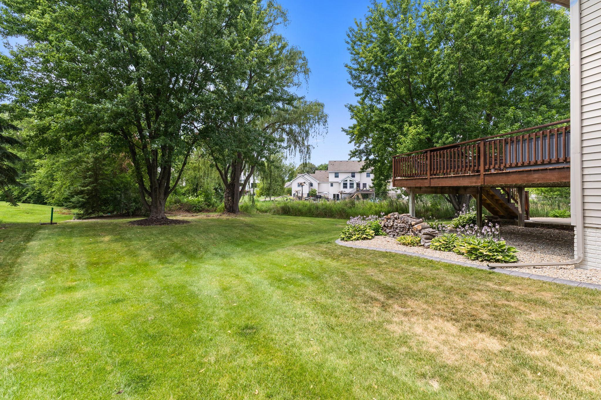 A spacious yard surrounded by mature trees offers privacy and room to play.