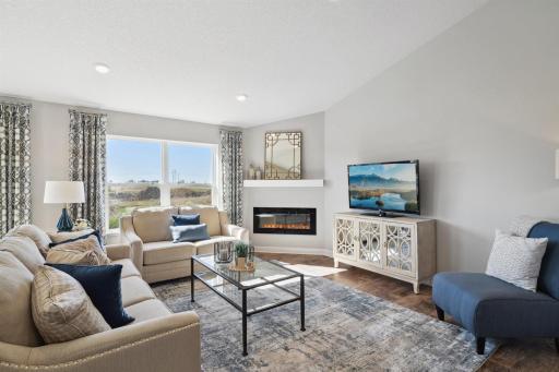 Family room includes electric fireplace with mantel and extended flooring.