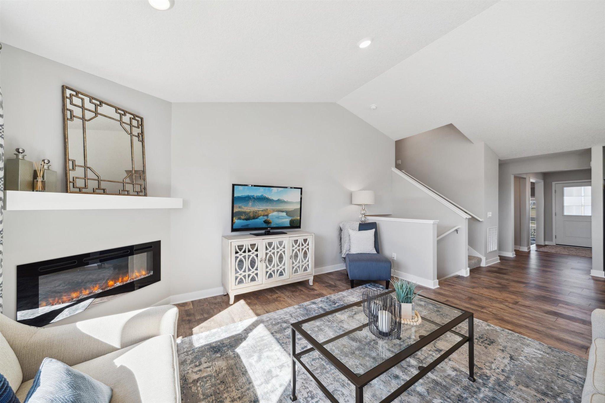 Family room includes electric fireplace with mantel and extended flooring.