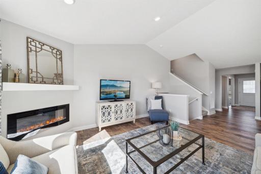 Family room includes electric fireplace with mantel and extended flooring.
