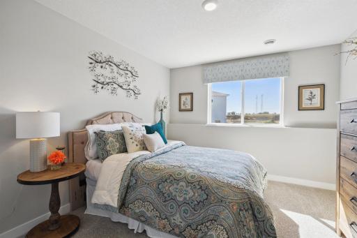 A forth bedroom resides on the lower-level, located across from a full bath. Photo of model, colors and options will vary.