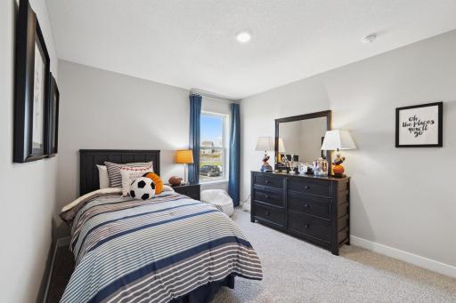 In addition to the primary bedroom, the home's upper level also includes these two additional bedrooms, and another full bathroom just adjacent to each! Photo of model, colors and options will vary.