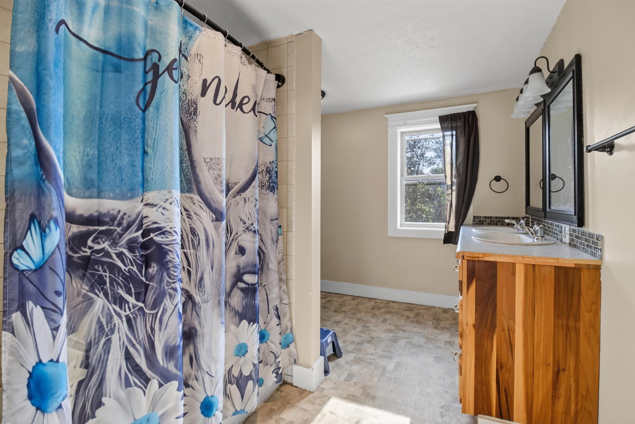 Upper level full bathroom featuring double sinks and laundry