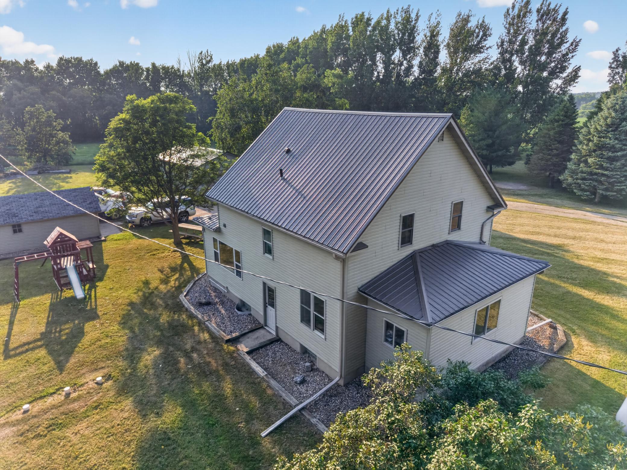 Featuring a metal roof on the home and 2-car detached garage. Swing set stays with the property