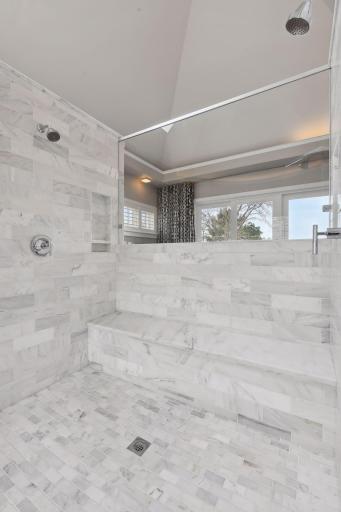 The large walk-in shower centered in the middle of the primary bath space makes quite the statement