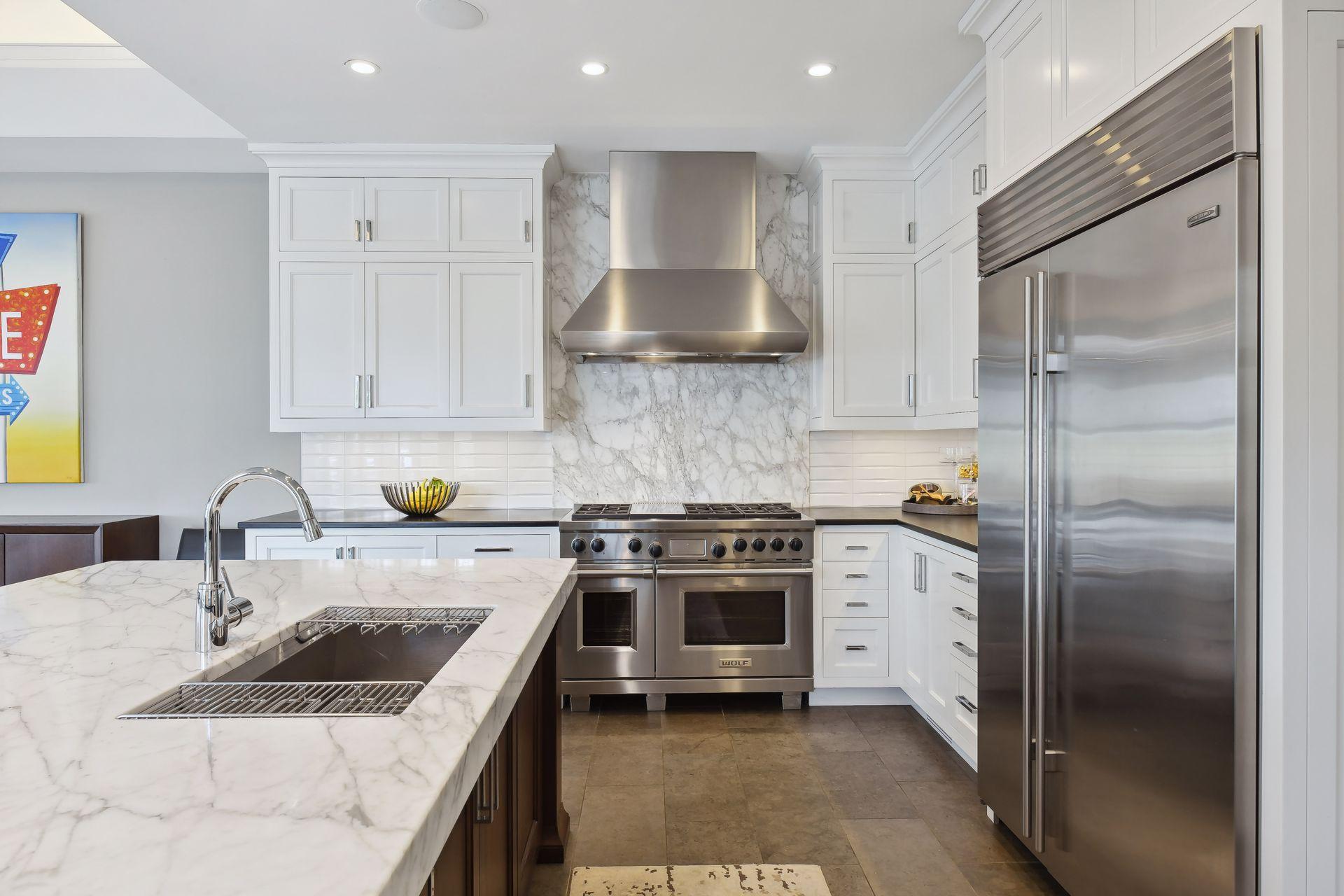Beautiful quartz countertops and backsplash along with crisp white subway tiles make for a clean and modern look in the kitchen