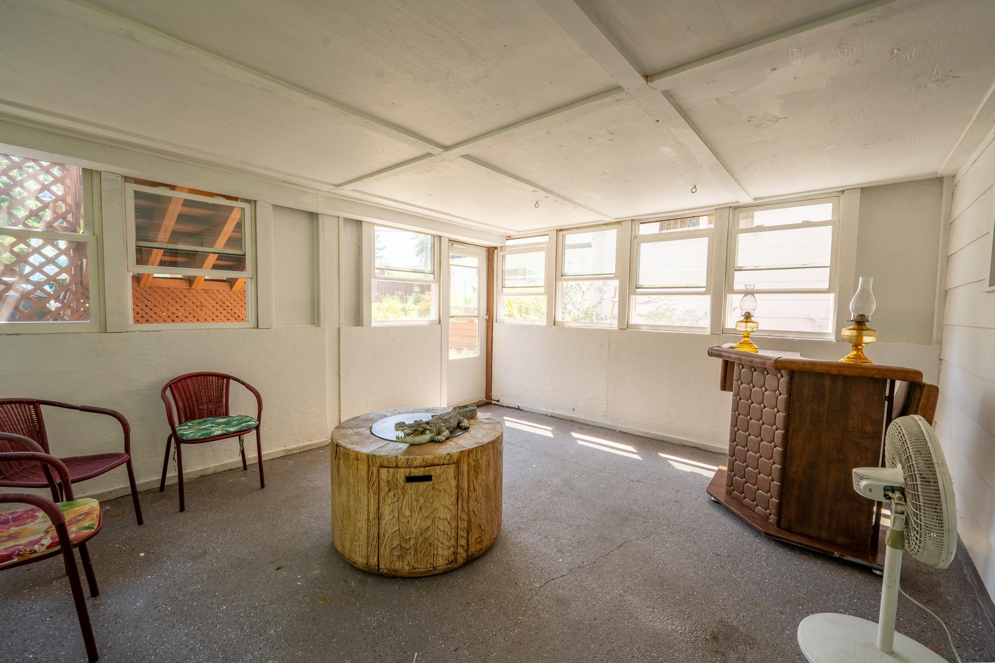 The three season porch is below the deck. You can access it from the family room and the door on the back leads to the backyard. You can see the steps leading up to the deck through that window. It's a wonderful place to use from spring through fall