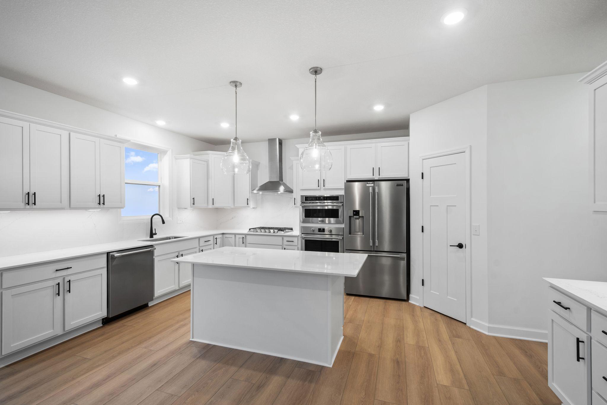 This stylish and multifunctional kitchen comes complete with brand-new stainless steel appliances, sleek quartz countertops and Shaker-style cabinetry.
