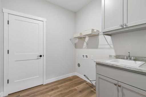 Dedicated laundry room with sink and storage