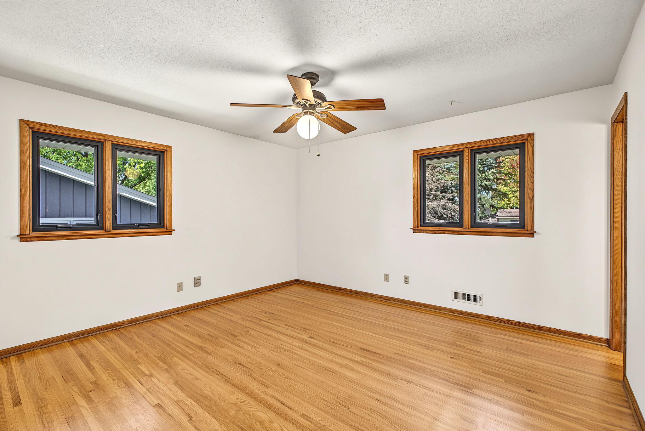 Primary bedroom with gleaming original hardwood floors.