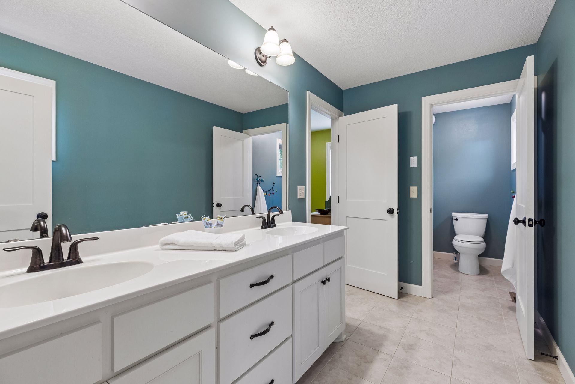 Jack and Jill bath with dual vanities and private full bath
