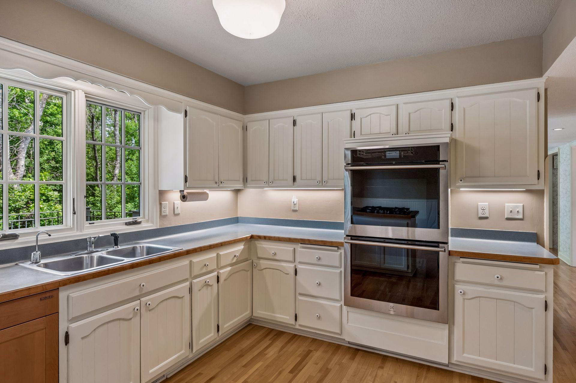 Bright, neutral kitchen with brand new double ovens and newer dishwasher
