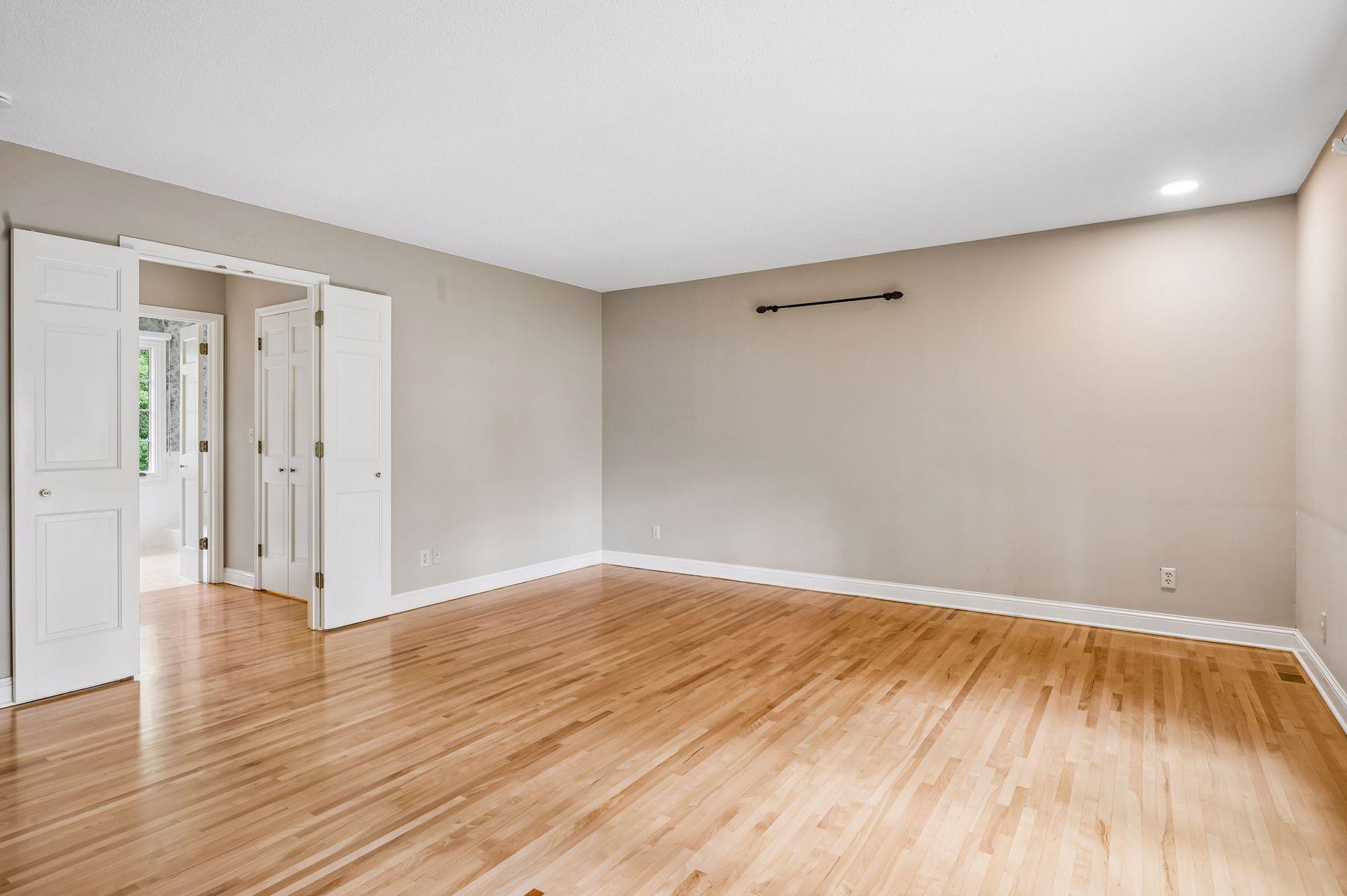 Main floor primary bedroom with double doors to ensuite and closet
