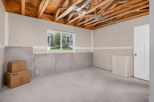 Unfinished basement with an egress window, and a plumbed in bathroom