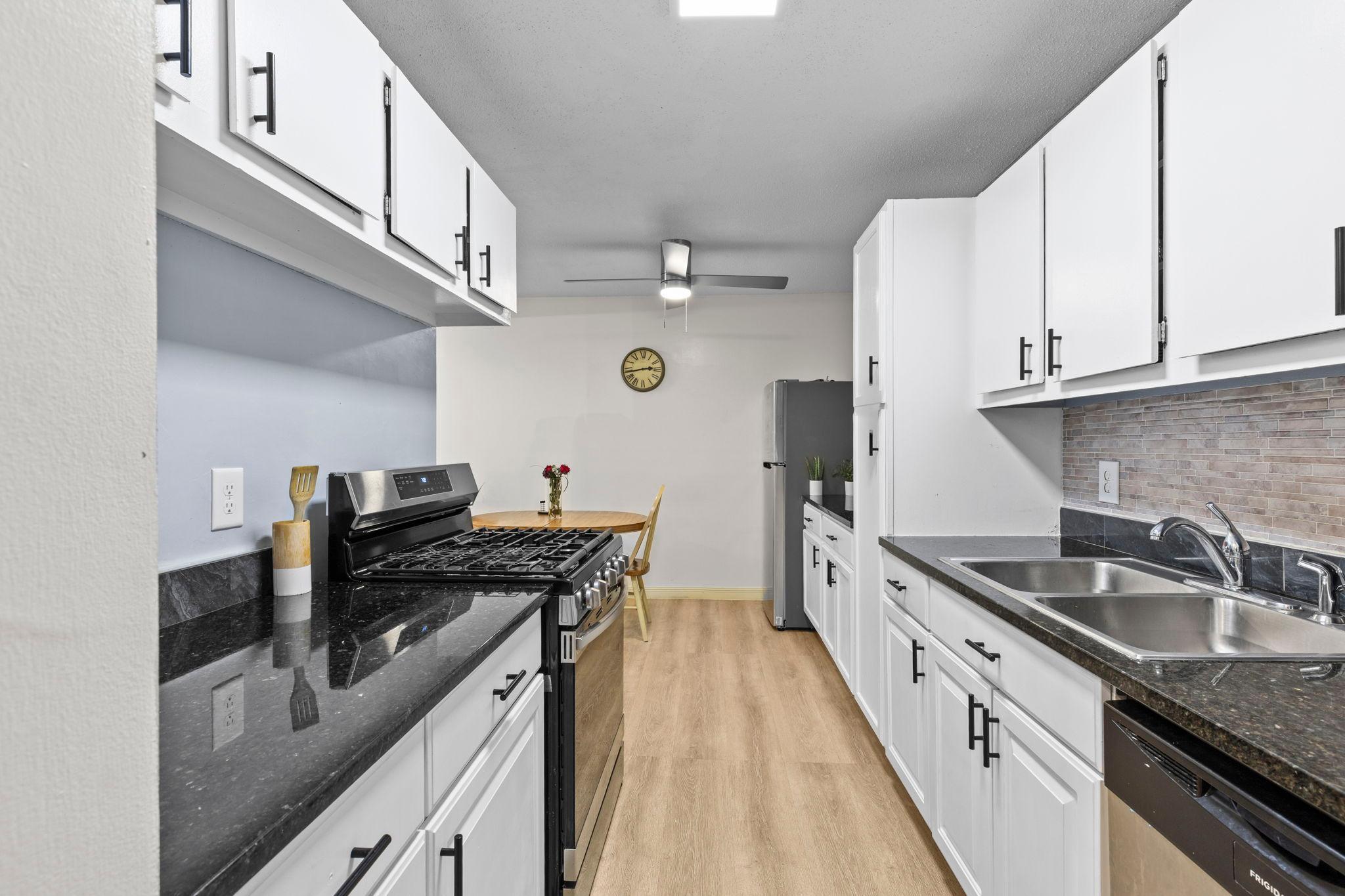 The kitchen offers stainless steel appliances, ample white cabinetry, and generous granite countertops, creating a functional and inviting space that flows seamlessly into the dining area.