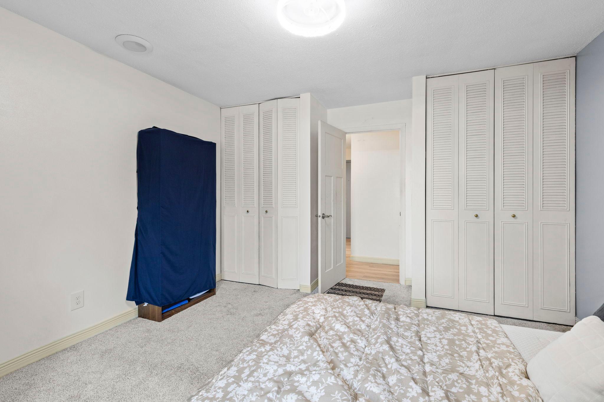 Another view of the bedroom showcasing the dual closets and providing ample storage space.