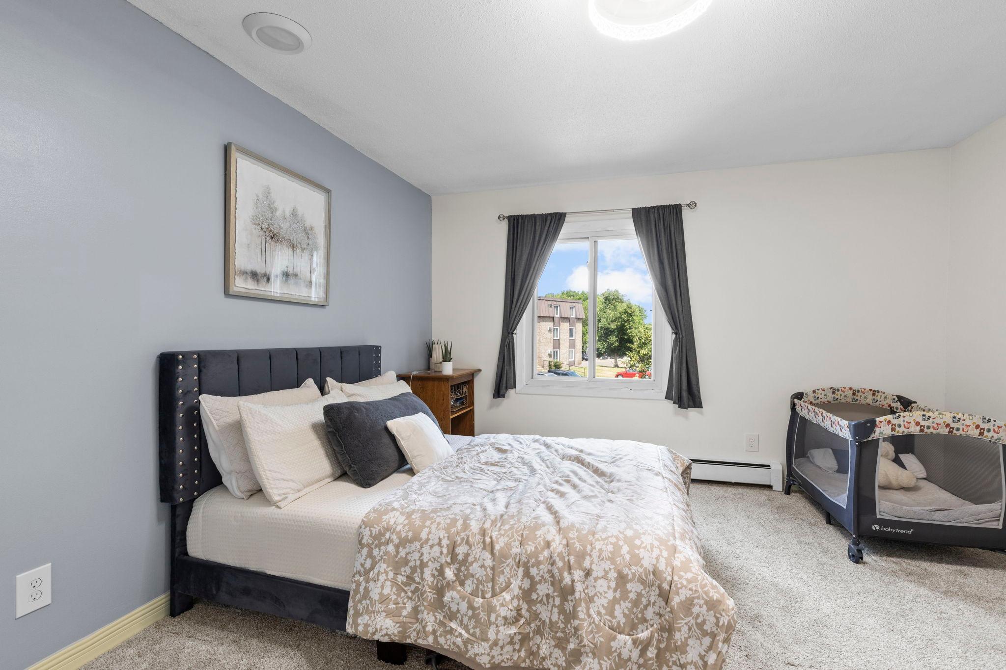 The spacious bedroom offers dual closets and carpeting.