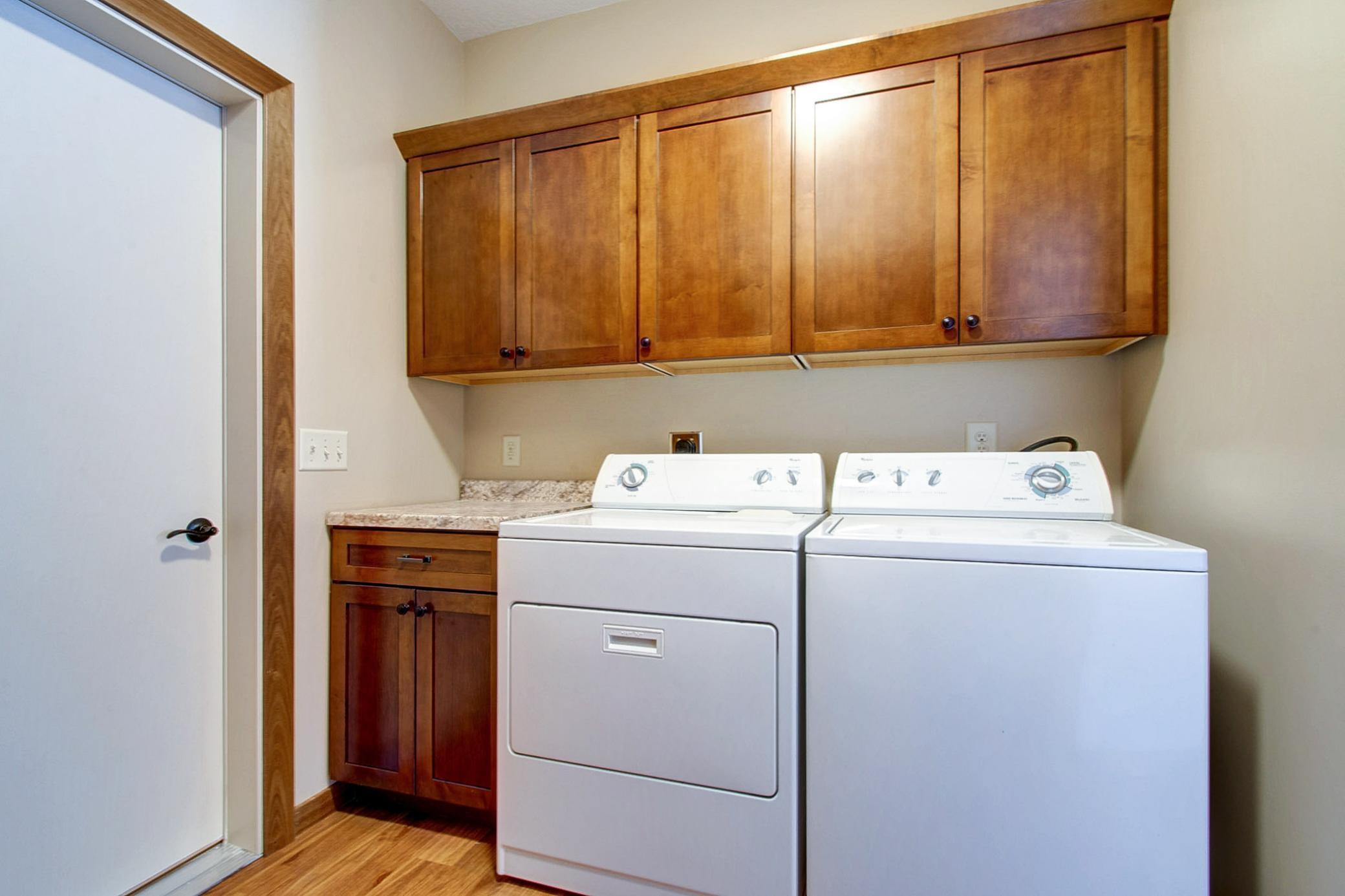 Convenient washer and dryer area has lots of storage.