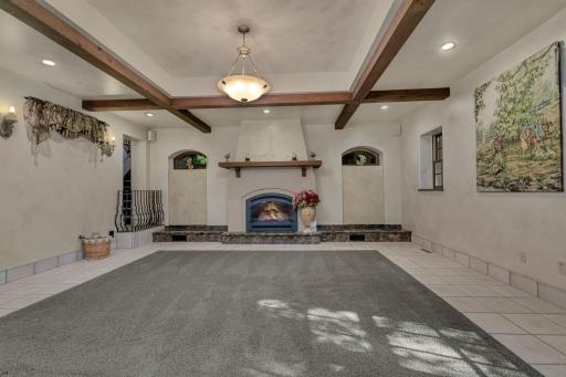 Gas fireplace with mantel surround crafted to match the French Country theme woven throughout the additions.
