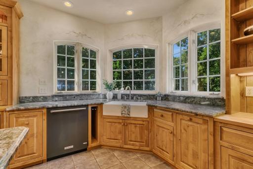 Windows surround the farmhouse kitchen sink.