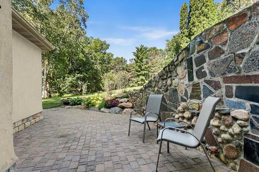 The charm and care of this patio and granite retaining wall will impress.
