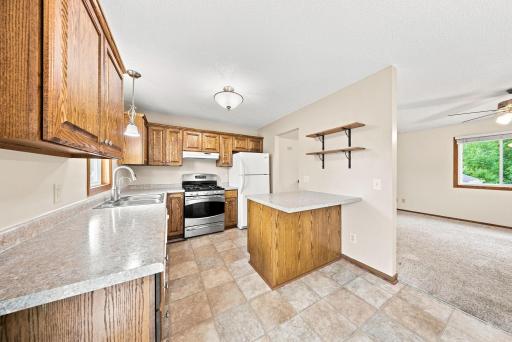 Kitchen with center island, gas range, and ample storage.
